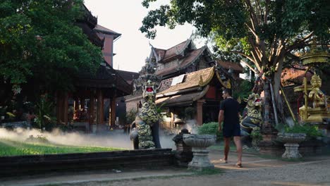 a man walking through a thai temple complex