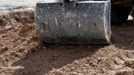 excavator removing brown earth with small shovel