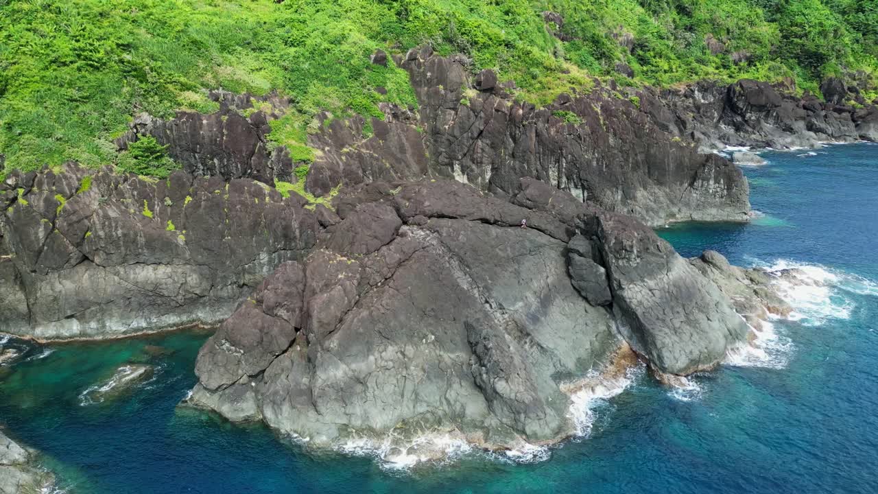 órbita aérea de la impresionante roca costera dentada frente a las aguas agitadas del océano en la isla de catanduanes