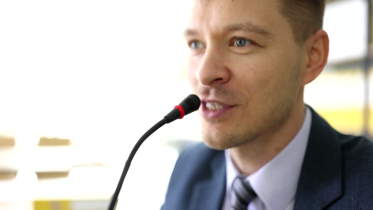 Ritratto di persona di sesso maschile seria che parla al microfono