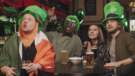 friends watching sports match in irish pub