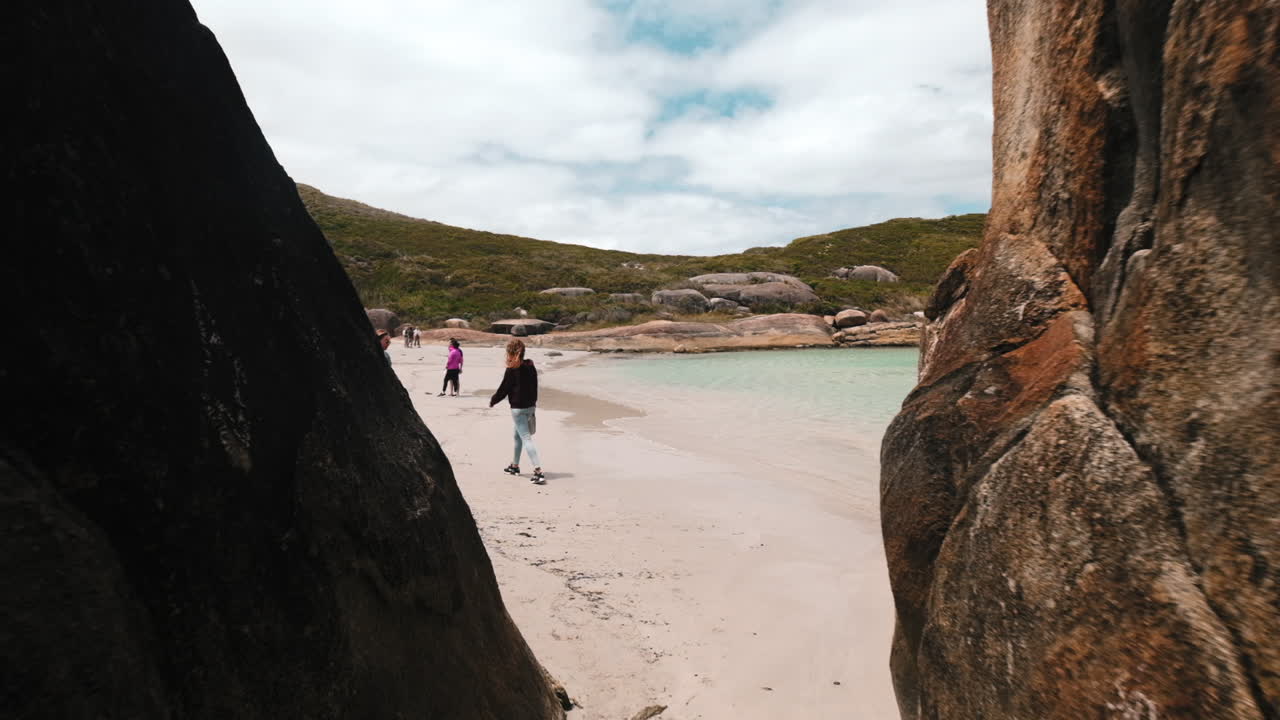 Slow motion forward shot showing group of young people exploring beautiful beach and ocean in Australia
