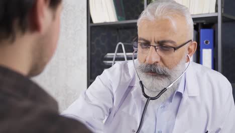 senior doctor examining his patient with a stethoscope.