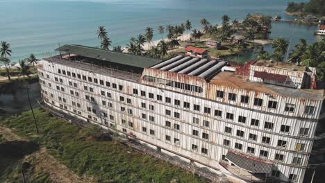 drone monitoring roof top of an ocean hotel-resort-building, top view of the drone over the roof of old land locked ferry