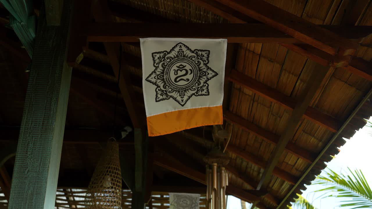 om ritual mandala toch colgado en un poste de madera en bali indonesia soplando en el viento en cámara lenta durante un viaje de verano