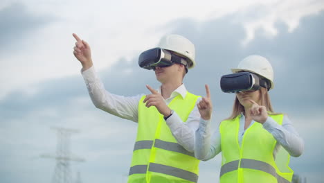 líneas eléctricas de alto voltaje bajo el control de dos ingenieros que utilizan la realidad virtual para controlar la energía. fuentes de energía alternativas en una ciudad moderna.