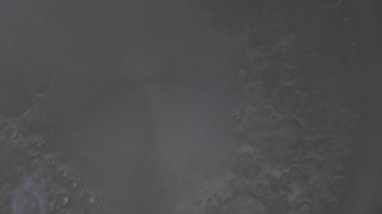 verter agua en una olla en una estufa de gas, preparándose para llevarla a ebullición