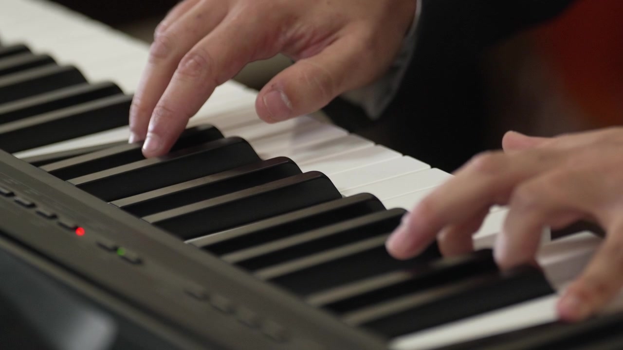 Hands playing piano keys in slow motion