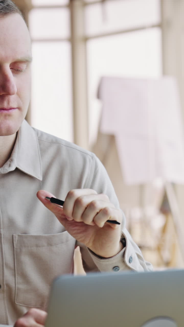 Focused man with concerned look stares at his laptop. Businessman becomes happy about the result and makes cheerful expression. Close up. Vertical video