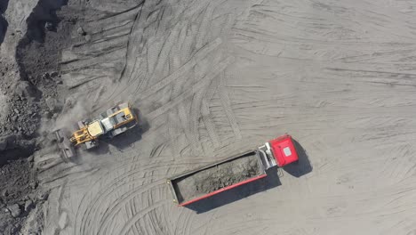 Aerial-view-loading-bulldozer-in-open-air-quarry