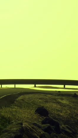 mysterious road winding through foggy landscape under bright yellow sky