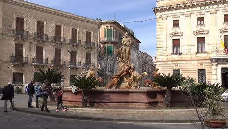 famous fontana di diana (fountain of diana) at the town square with a famous statue and tourists going around