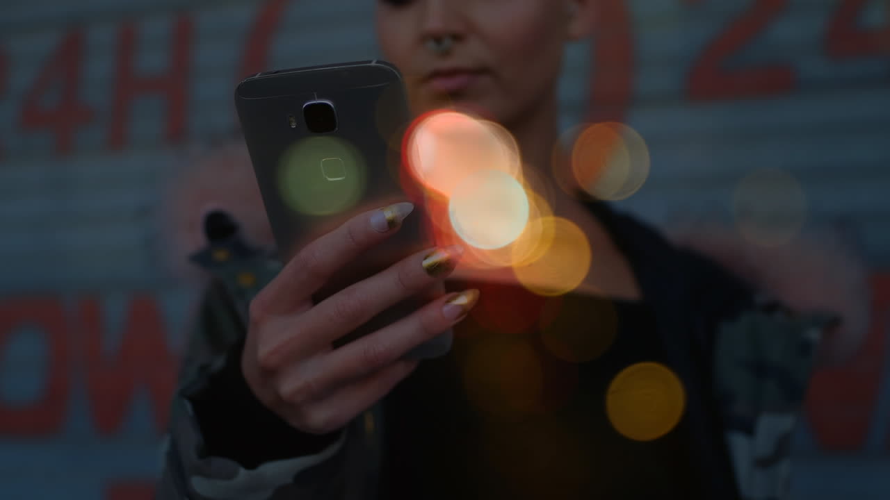 mujer usando un teléfono móvil rodeada por el efecto bokeh