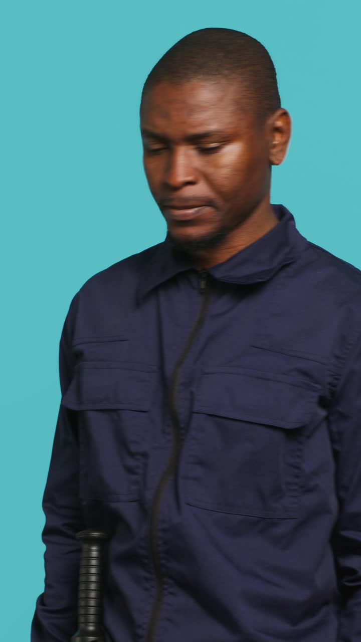 Uomo afroamericano triste con uniforme blu che guarda in basso