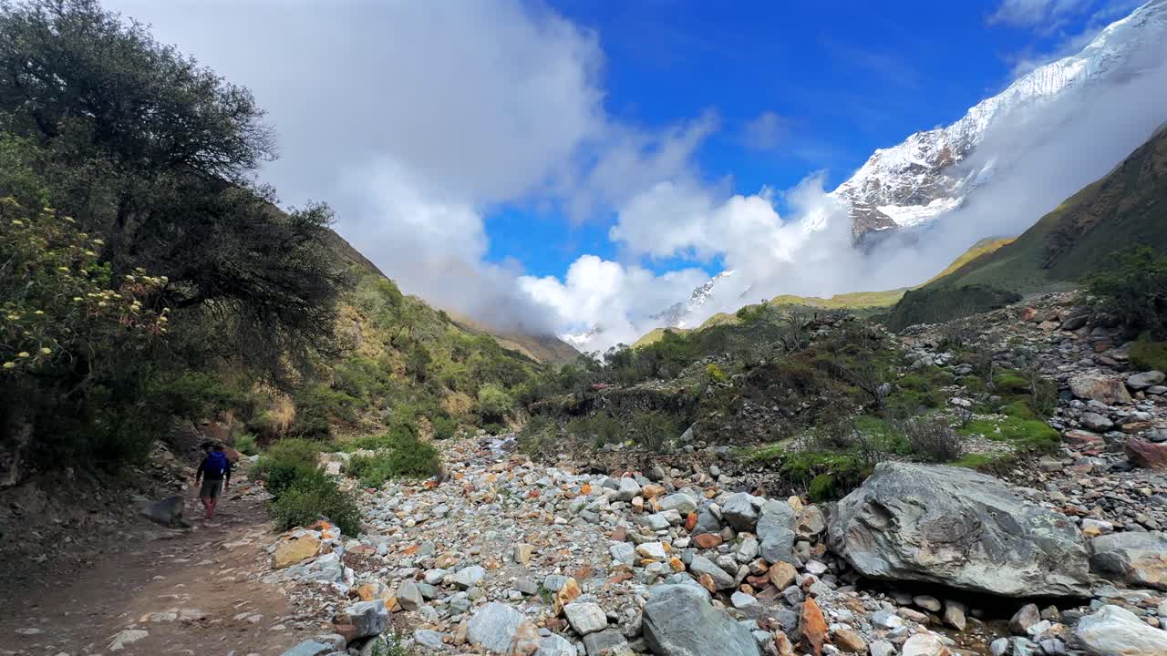 Mount Humantay Peruvian Andes snow capped glacier mountain Salcantay Inca trail trek hiker Peru low fog clouds blue sky rainy dry season Laguna Humantay Soray Anta Cusco region nature landscape pan