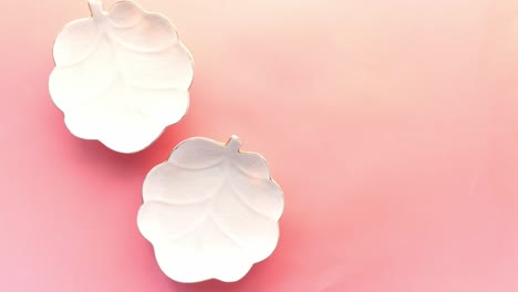 elegant white leaf-shaped dishes on pink background