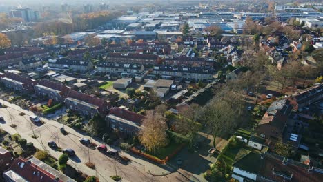 una foto aérea de un hermoso barrio suburbano en un soleado día de otoño - un avión no tripulado volando hacia atrás