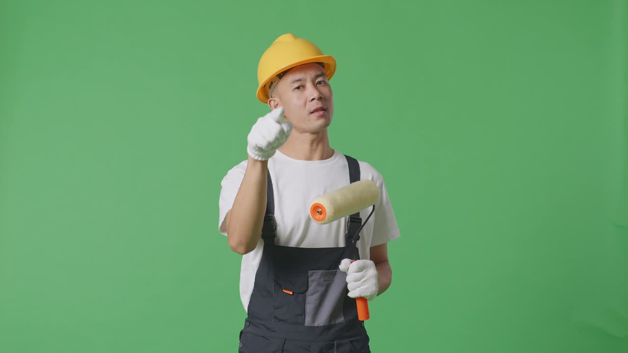 Asian Man Painter Wearing Safety Helmet Shouting To Camera While Standing In The Green Screen Background Studio