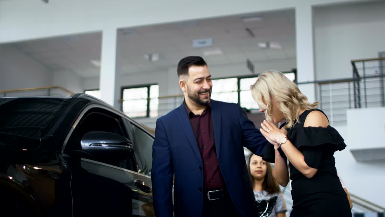 familia feliz consiguiendo un coche nuevo en el salón