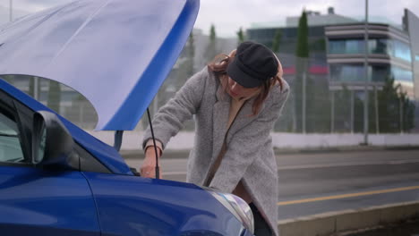 una mujer arreglando un coche averiado.