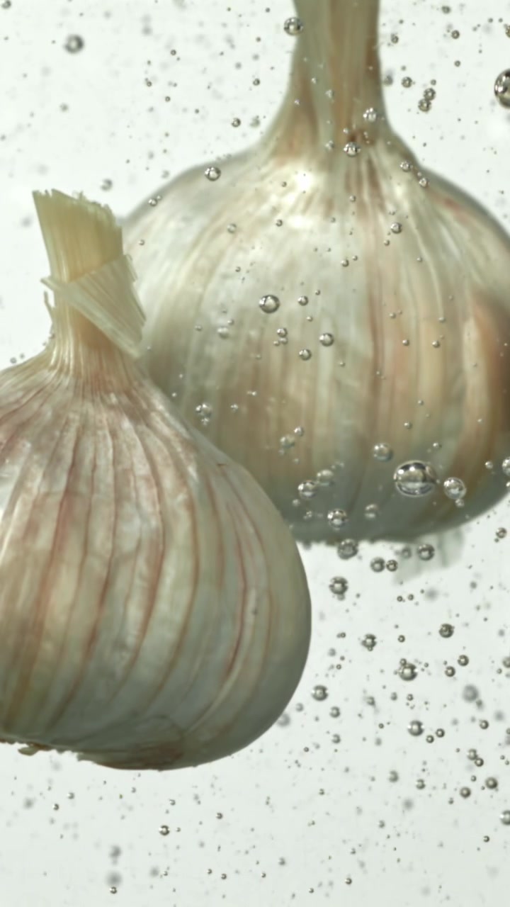 Primo piano di bulbi d'aglio immersi in acqua che ribolle