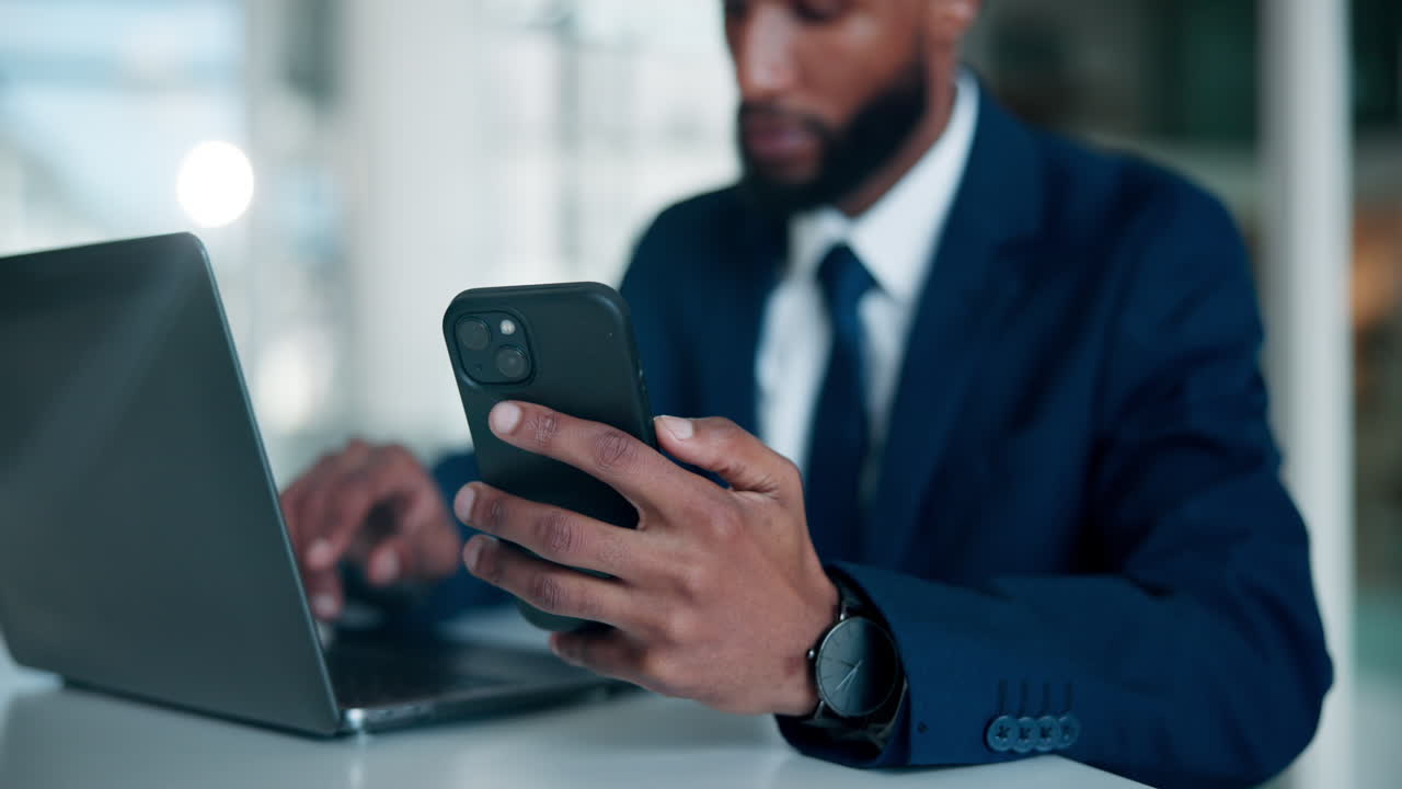 Empresario usando el teléfono y el portátil en la oficina