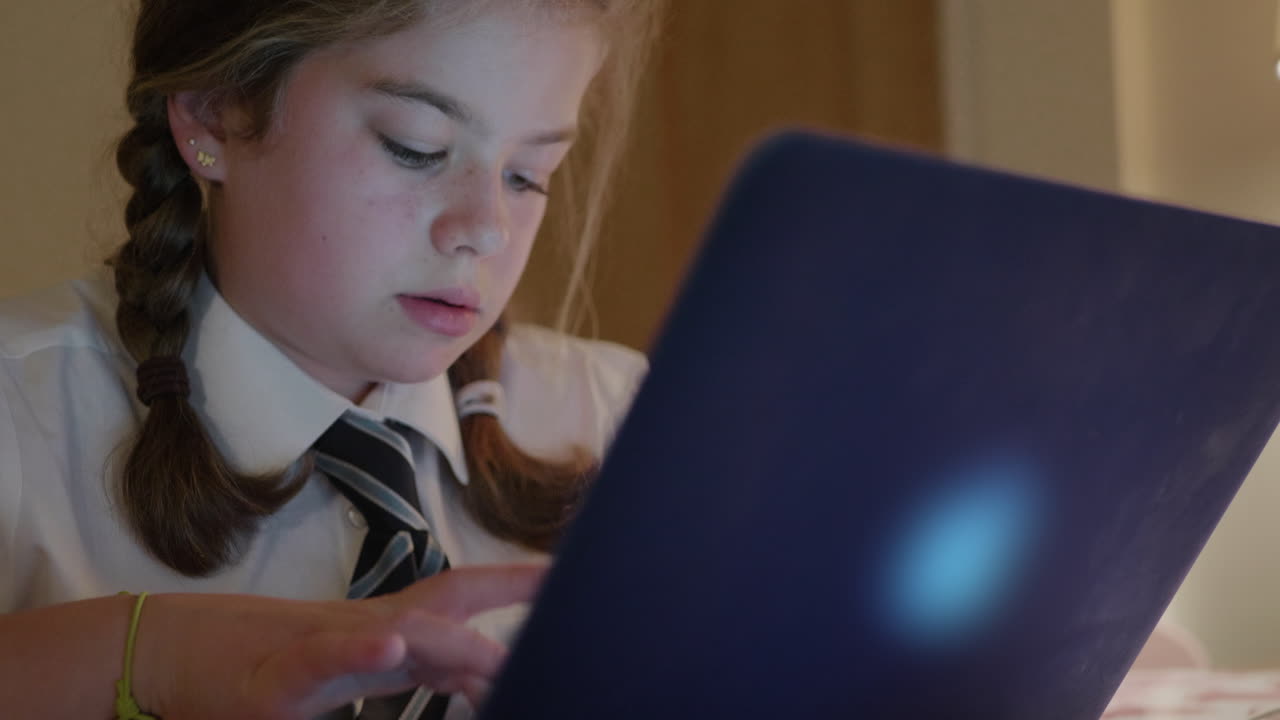 어린 여학생이 노트북으로 숙제를 한다