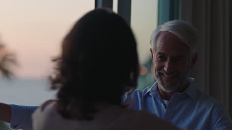 happy-mature-couple-dancing-at-home-enjoying-successful-relationship-having-fun-celebrating-anniversary-retirement-on-vacation-at-sunset