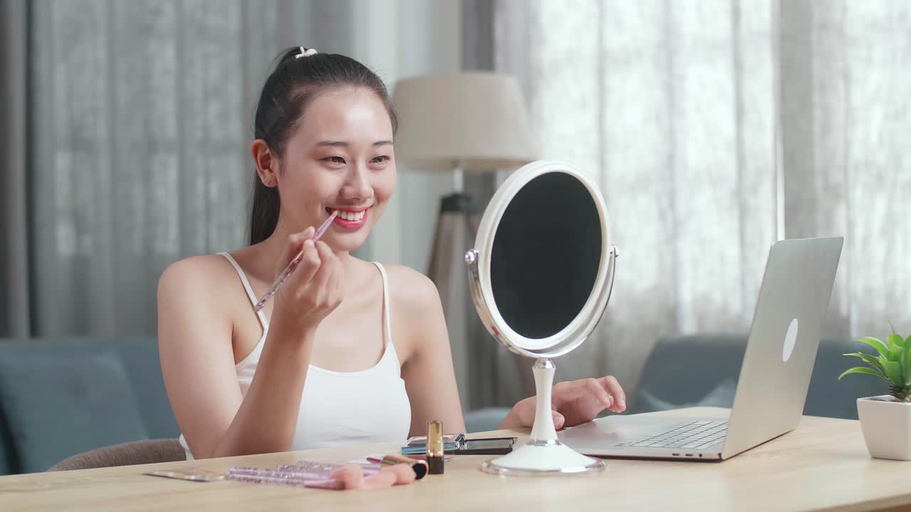 노트북 앞 에서 메이크업 을 하는 여자