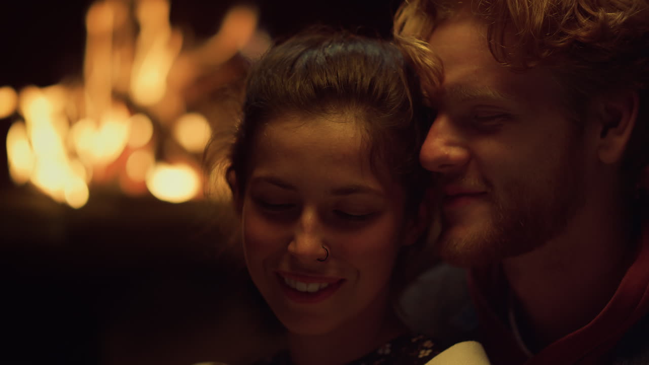 una pareja alegre disfruta del primer plano de la chimenea. amantes sensuales se abrazan en la cita.