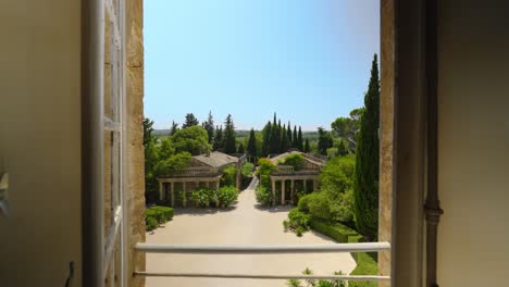 Scenic-View-from-Castle-de-Castille's-Window,-Roman-Pavilions-and-Lush-Greenery-Unveiled