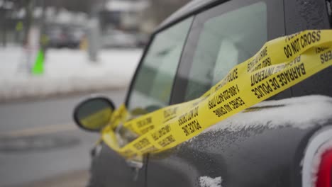 side view of caution tape on a crashed car on the side of the road