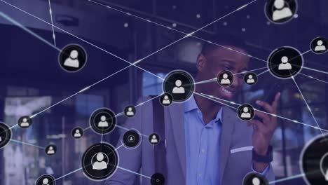 animation of network of connections with icons over african american businessman using smartphone