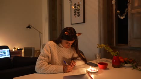 mujer escribiendo una carta en casa por la noche
