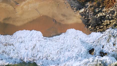 Ein-Mann-Liegt-Am-Strand-Und-Formt-Einen-Sandengel-Im-Sand,-Gesehen-Von-Einer-Drohne-über-Ihm