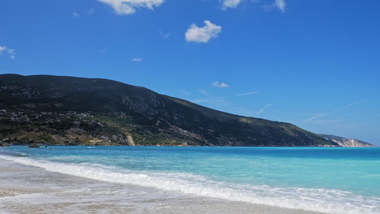 Onde azzurre e limpide sulla splendida sabbia della spiaggia di Agia Kiriaki in Grecia - Ampia.