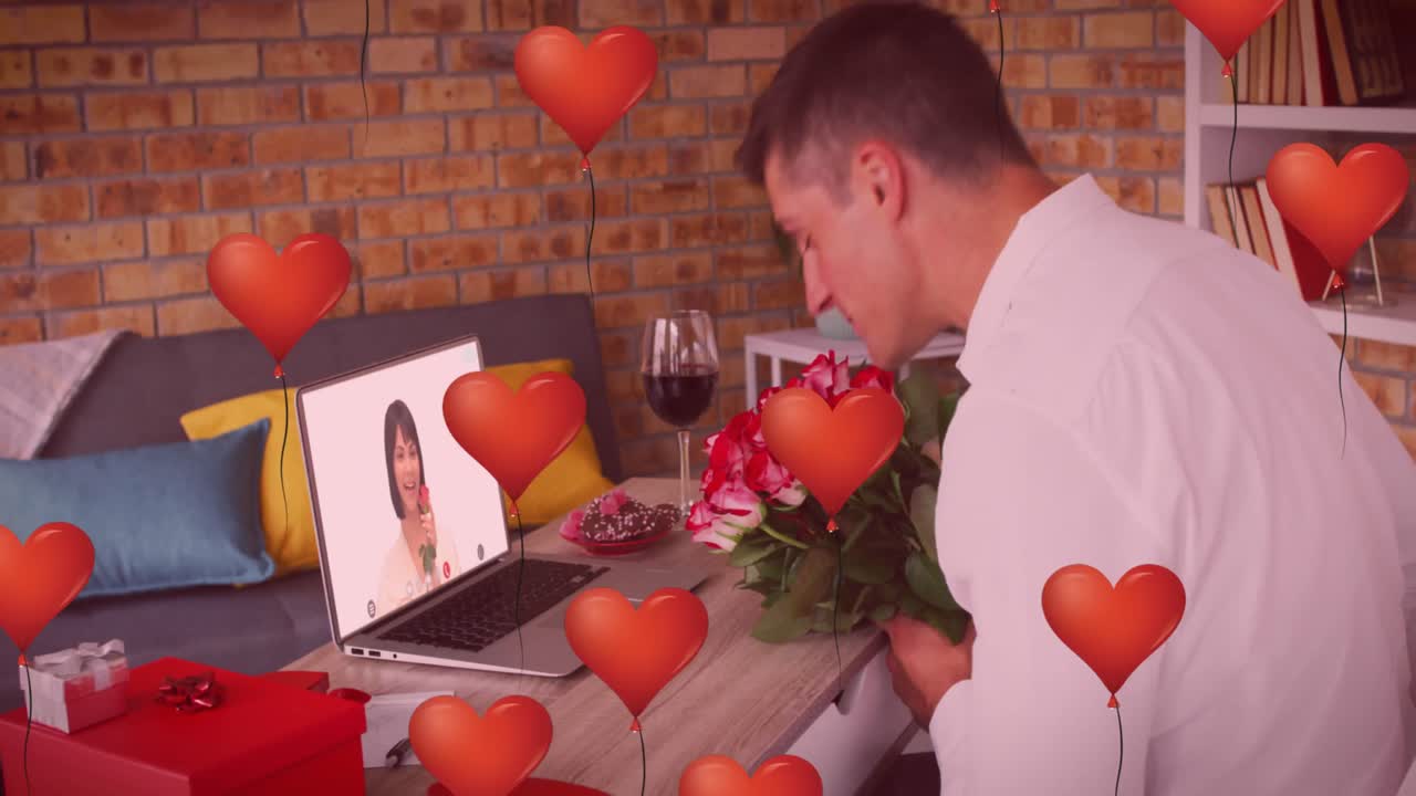 노트북에서 비디오 통화를 하는 동안 꽃봉오리를 들고 있는 백인 남성 위에 심장 모양의 풍선