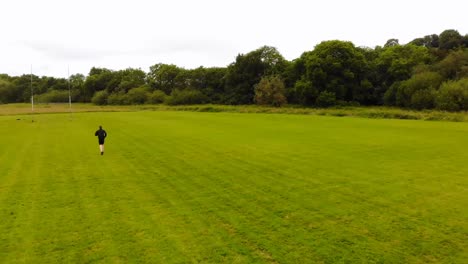 uomo che corre in un campo verde in un giorno di brezza 4k