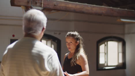 Young-dance-teacher-talking-with-senior-people-before-class