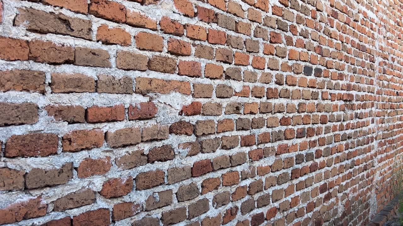 Close up view of old rustic brick wall background with rough mortar and diagonal perspective lines