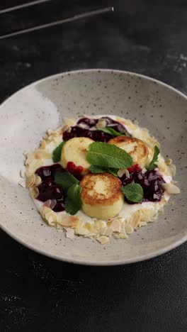 syrniki with cherry sauce and almonds