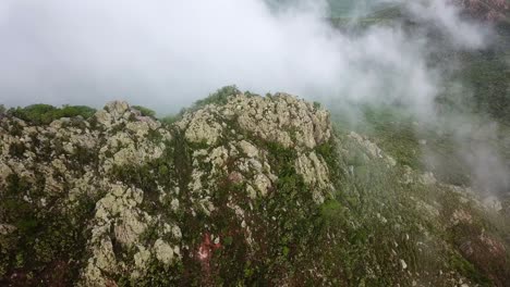 aerial view dolly in tilt down of mount cristobal , the only mountain on the dutch island of curacao in the caribbean, foggy day