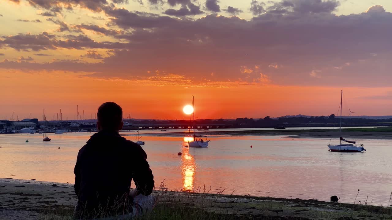 Person Relaxing at Malahide Marina Watching Peaceful Boats During a Glowing Irish Sunset