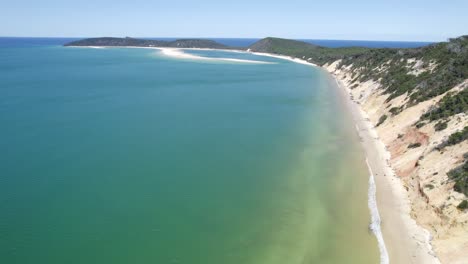océano tranquilo y turquesa en la playa del arco iris en qld, australia - disparo de drones