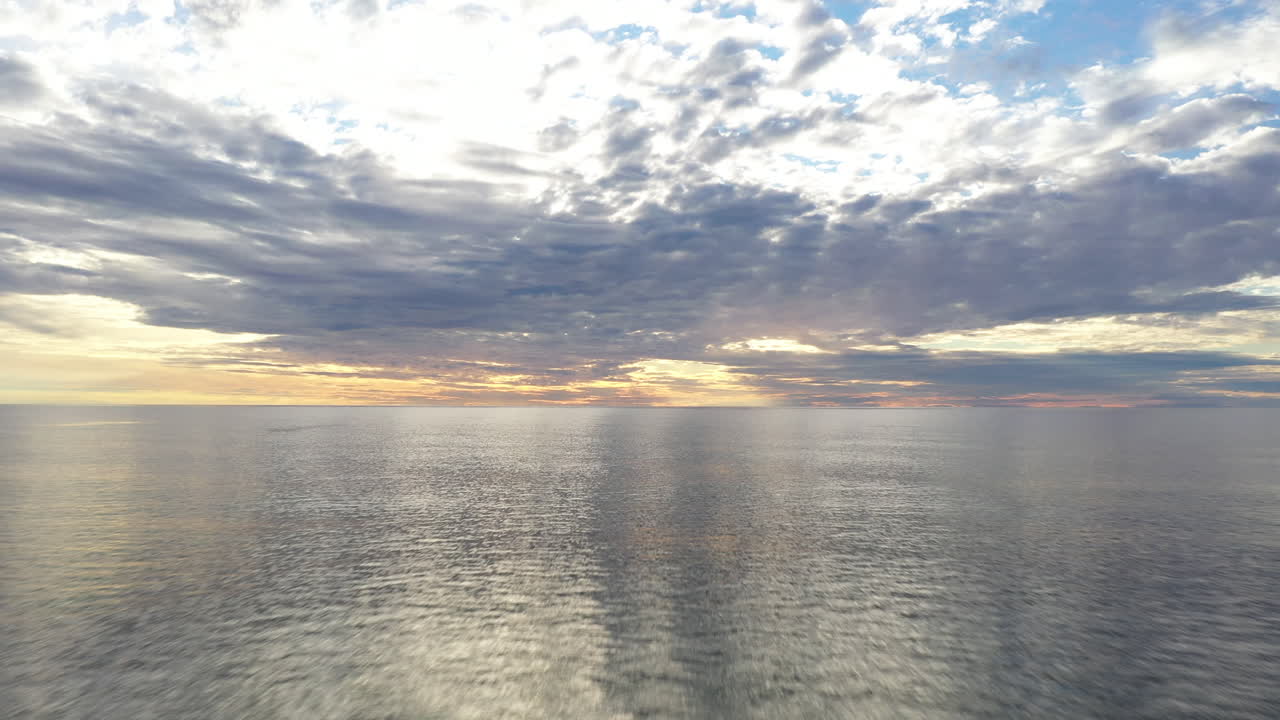 aéreo: volando muy bajo sobre el mar báltico durante la hora dorada hacia el horizonte