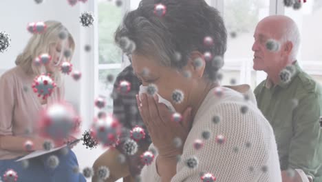 multiple covid-19 cells floating against sick african american senior woman sneezing at home