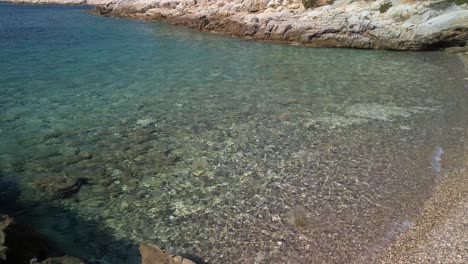A-crystal-clear-pebble-beach-with-sharp-rocky-sides-on-the-island-of-Vis-in-Croatia