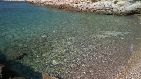 a crystal clear pebble beach with sharp rocky sides on the island of vis in croatia