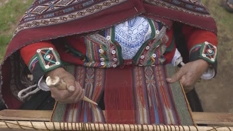 peruvian weaver works on a loom