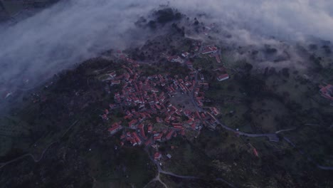 Von-Oben-Nach-Unten-Aufnahme-Des-Dorfes-Monsanto-In-Portugal-Mit-Sonnenaufgang-Bei-Niedrigem-Nebel,-Luftaufnahme